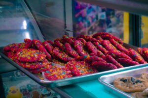 tray of bright pink cookies with fruity pebbles on them